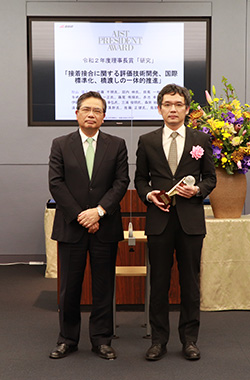 受賞者代表（秋山 陽久）（右）と石村理事長（左）の写真