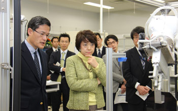 ライフサイエンス実験ロボット「まほろ」の実演をご覧になる島尻大臣(中央)の写真