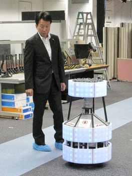 車輪型自律移動ロボットの実演をご覧になる大串政務官の写真