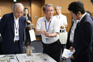 SIP「SiC次世代パワーエレクトロニクスの統合的研究開発」の説明をお聞きになる松山大臣（右）の写真
