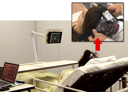 被験者がベッドでニューロコミュニケーターを使用している様子