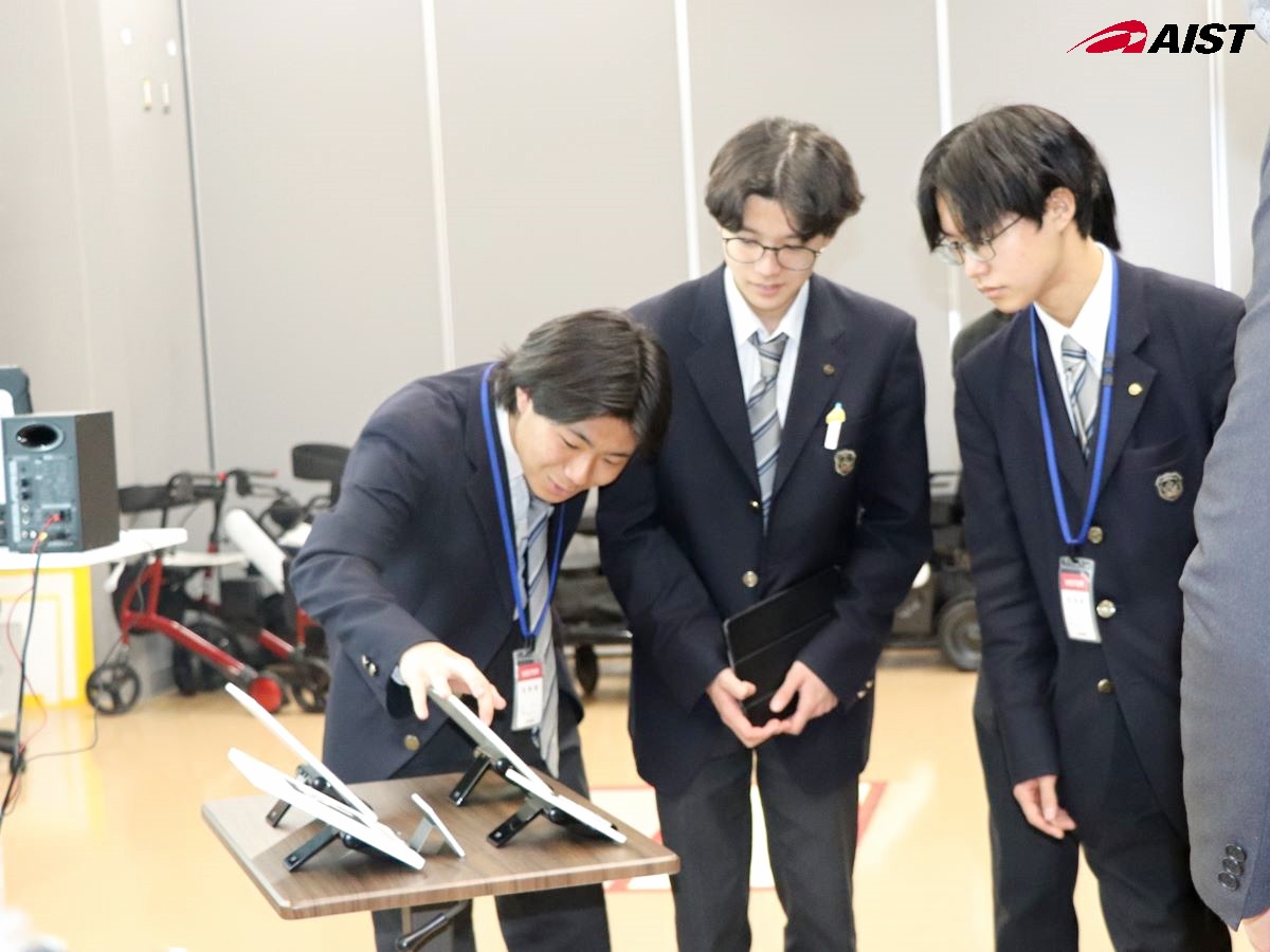 実験室でタブレット画面をのぞき込む高校生