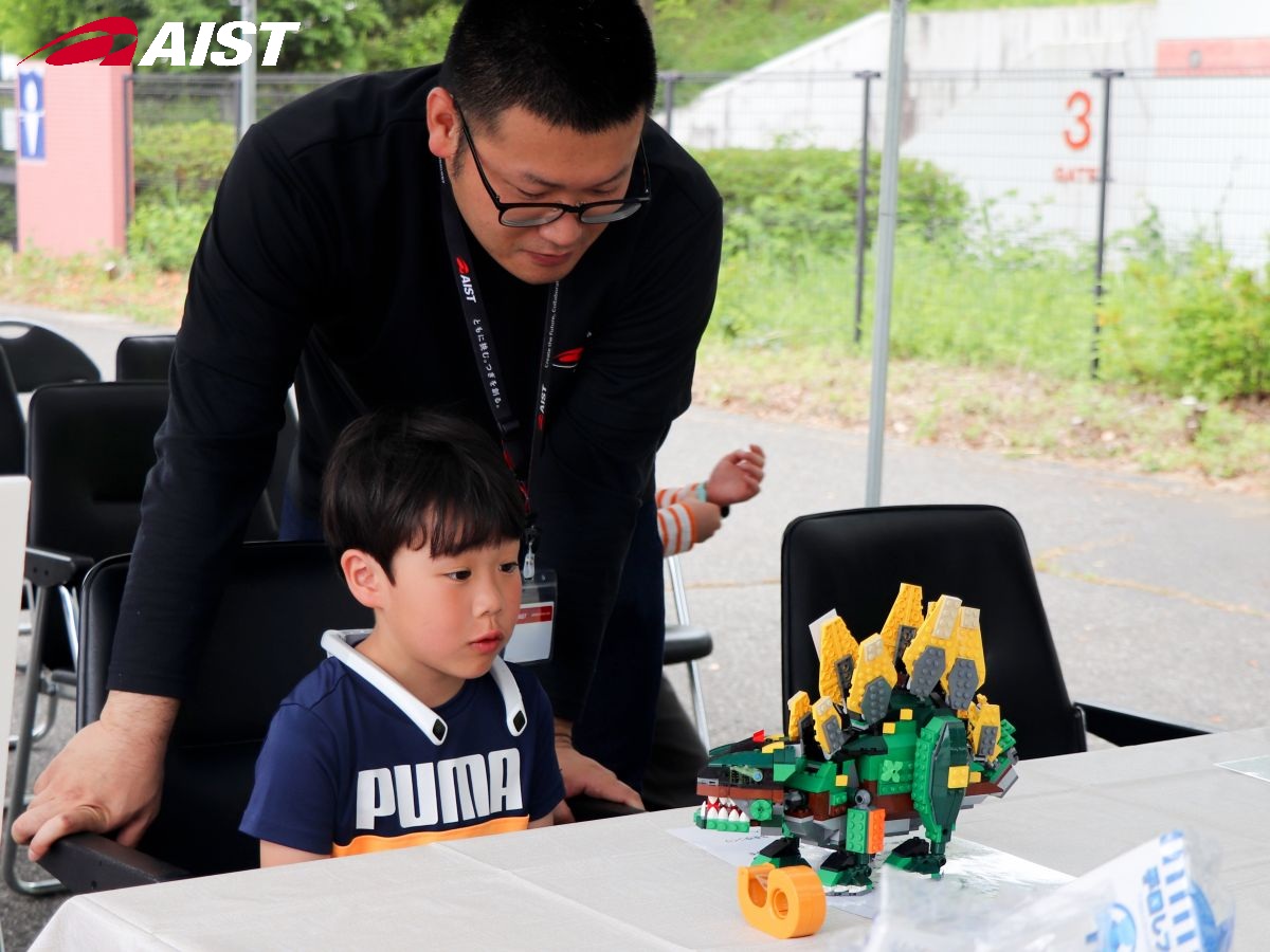 レゴブロックの恐竜の話を聴くお子さん