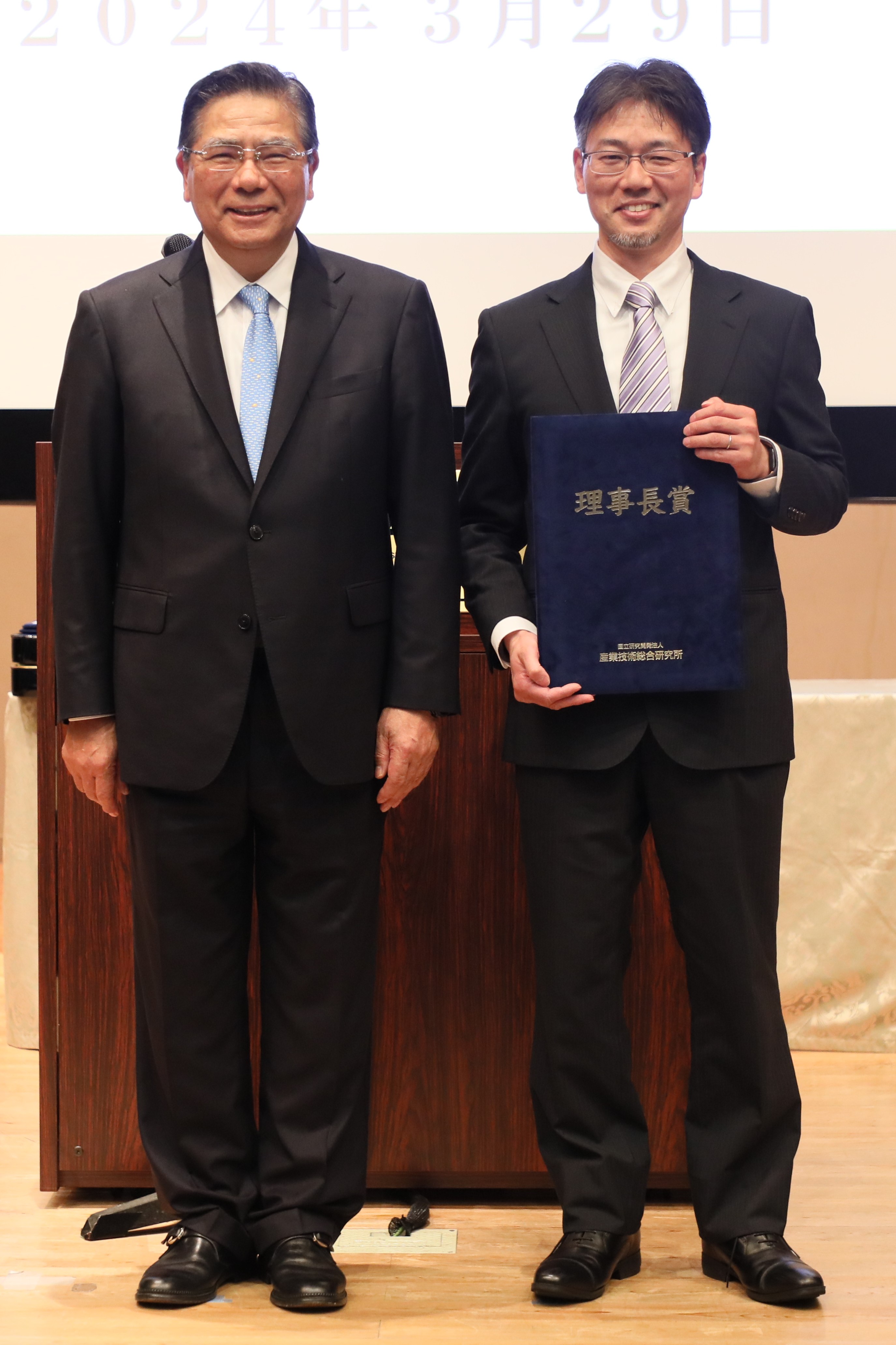 受賞者代表（濱崎 雅弘）（右）と石村理事長（左）の写真