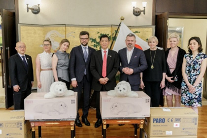 在ポーランド日本大使公邸で、ポーランドの2医療機関へ4体のPAROが手交される様子の写真