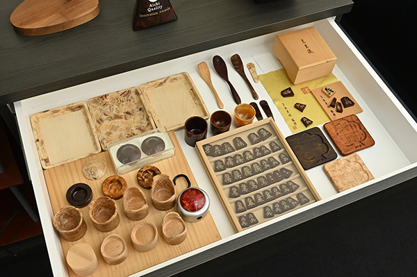 木質流動成形技術を用いたサンプルの数々、おちょこやスプーン、将棋の駒など