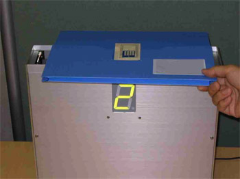 印刷無線IDタグを貼り付けた容器をリーダーに近づけて識別させる動作確認写真