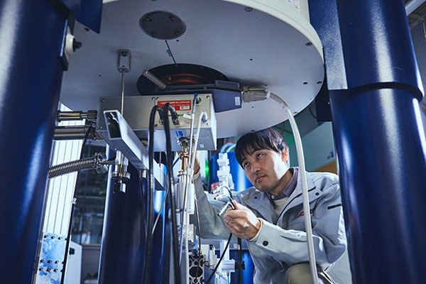 固体NMR装置の測定準備をする研究者