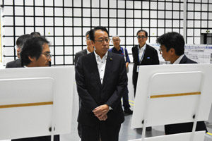 スマートシステム研究棟電波暗室で説明をお聞きになる長沢復興副大臣(中央)の写真