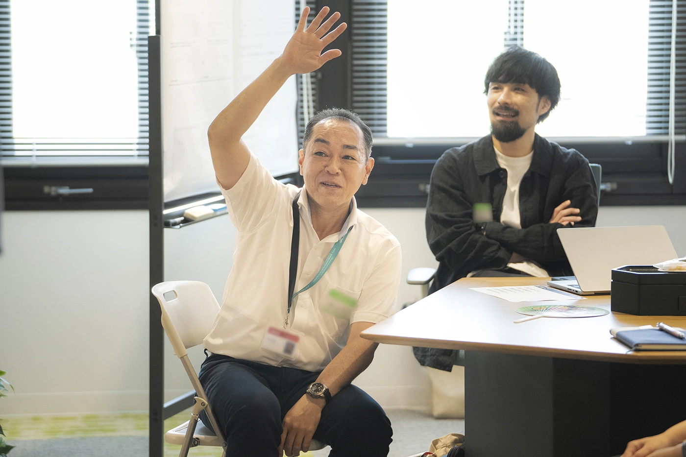 田丸雅智からの問いかけに対して、笑顔で元気に手を挙げる参加者の様子