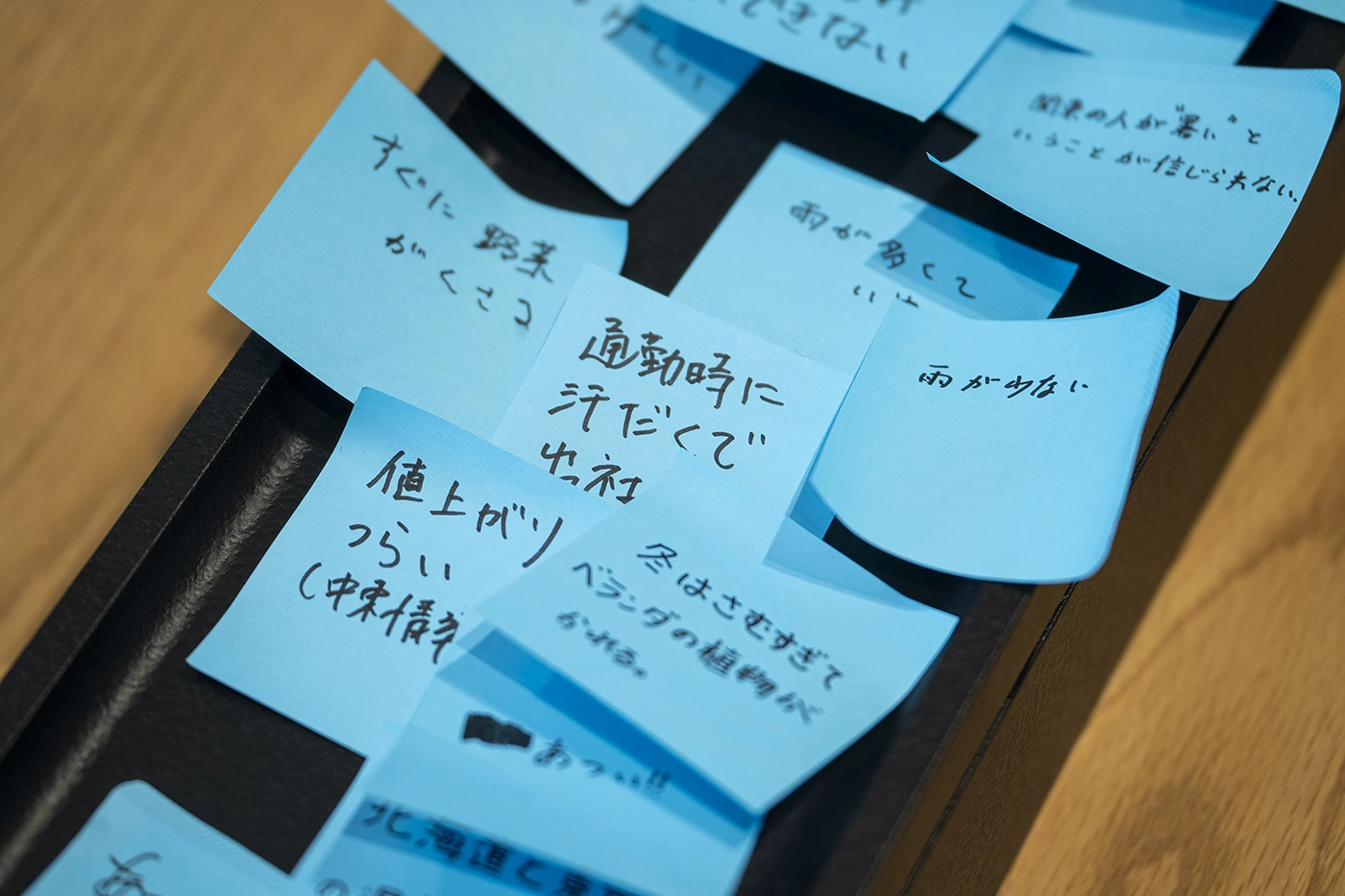 「通勤時に汗だく」などの日常のエピソードが手書きされた付箋群