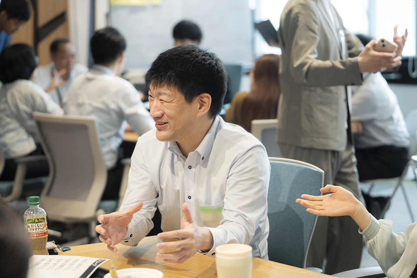 身振り手振りを大きく交えながら、デスクで身を乗り出して熱弁する参加者