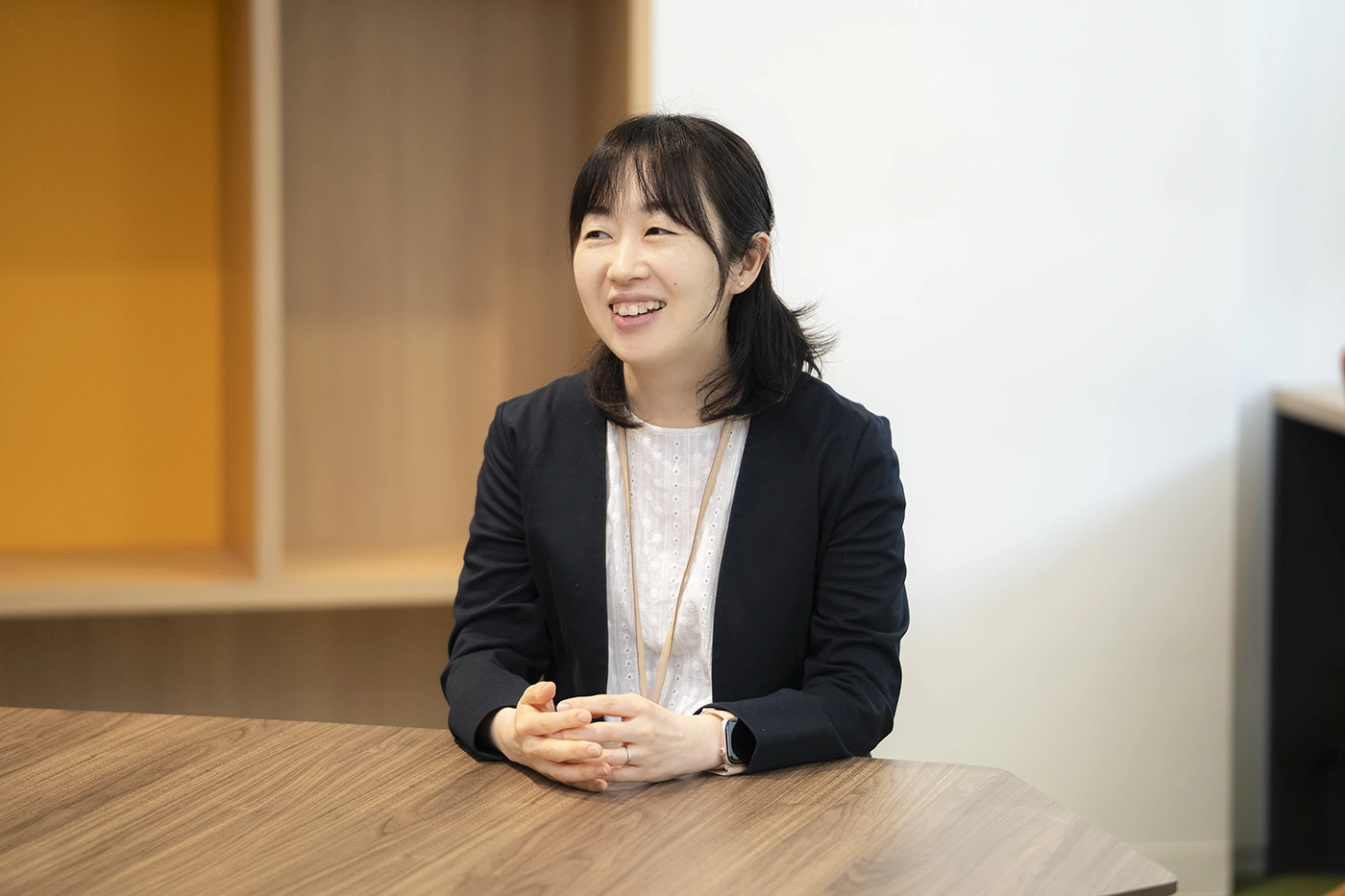 テーブルに両手を置き、温かい笑顔でワークショップへの想いを語る石川明由子
